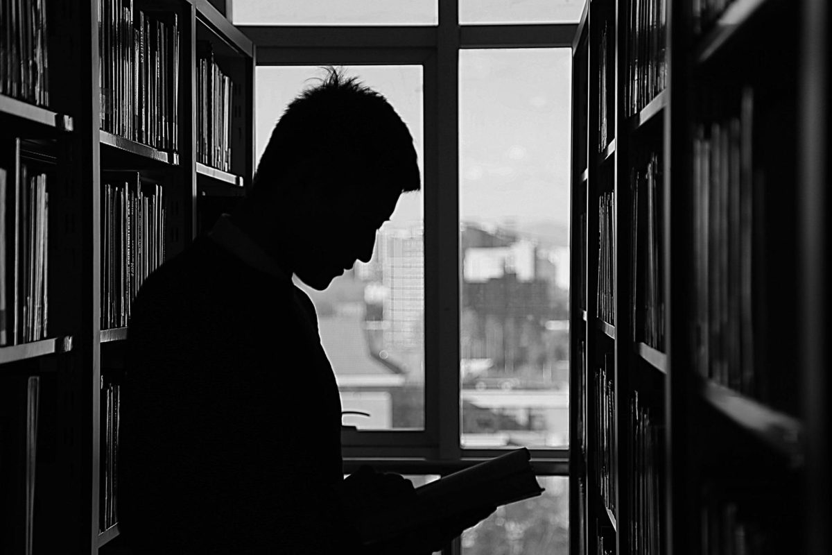 Student in library holding book.